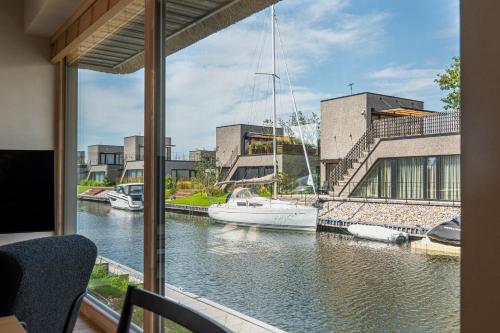 a view of a boat in the water from a balcony at Svencelės Salos Canal Villa in Svenele