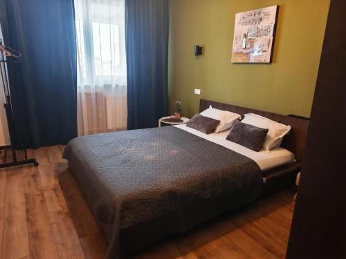 a bedroom with a large bed with blue curtains at Best City View in Craiova