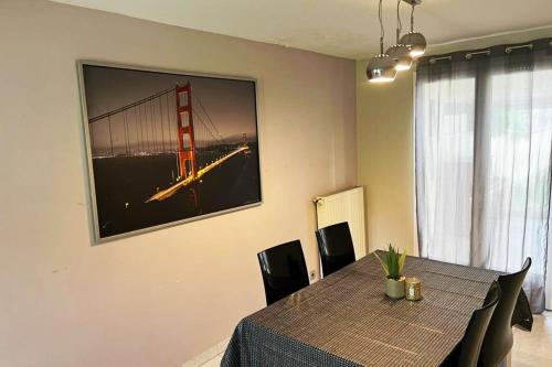オーベルヴィリエにあるSpacious house ideally locatedのダイニングテーブルと椅子、そしてゴールデンゲートブリッジの絵
