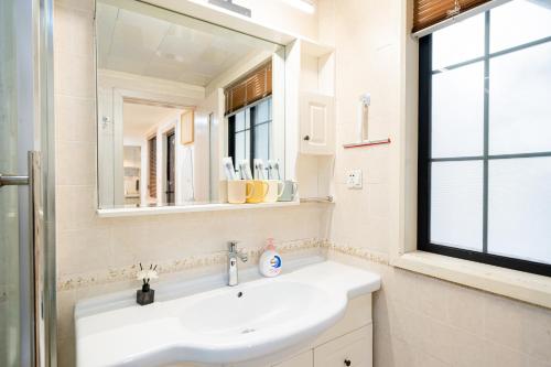 a bathroom with a sink and a mirror at Shanghai Hills & Well-time Woodland 2B Suite close to Photospot Wukang Mansion in Shanghai