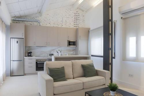 a living room with a couch and a kitchen at Royar 4 ático in Jaén