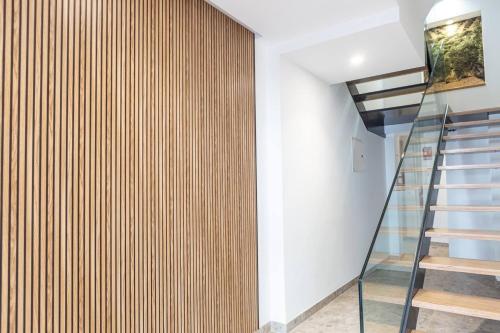 a staircase in a house with a wooden wall at Royar 4 ático in Jaén