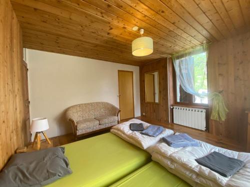 a room with two beds and a chair in it at CASA-Suite La Bohème pour 5 personnes in Molines-en-Queyras