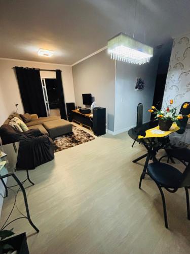 a living room with a couch and a table at Apartamento Completo Centro SJC - 3 quartos in São José dos Campos