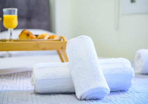 a pile of towels on a table with a glass of orange juice at Evripos escape in Chalkida