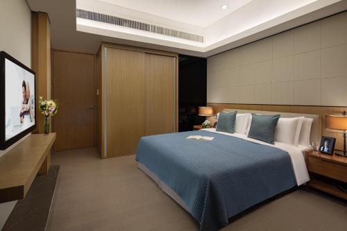a hotel room with a bed and a flat screen tv at Ascott IFC Guangzhou - Free Shuttle Bus For Canton Fair in Guangzhou