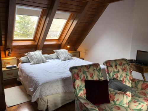 a bedroom with a bed and two chairs at Unique house in Arties in Arties