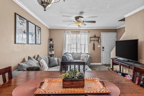 a living room with a table and a tv at Woodstone Retreat right next to UGA golf course in Athens
