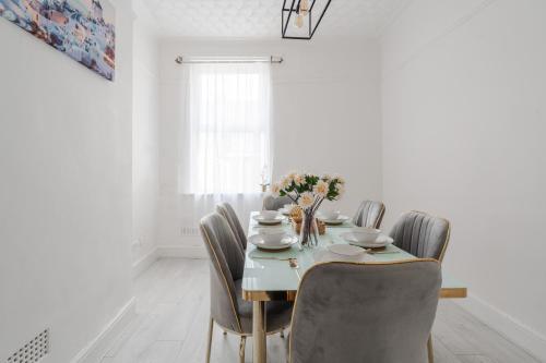 Un comedor blanco con una mesa y sillas. en Mersey View 4 Bedroom by Liverpoollux Next To Everton Stadium, en Liverpool