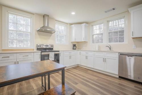 a kitchen with white cabinets and a table in it at Classic City Apartment w Firepit in Athens