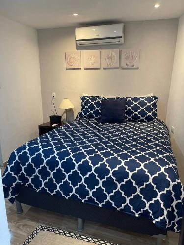 a bedroom with a bed with a blue and white comforter at Hidden House Casa Escondida in Santa Rosa