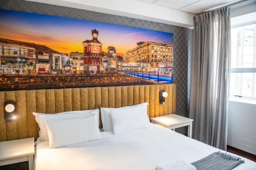 a hotel room with a bed and a painting of a city at Cape Diamond Boutique Hotel in Cape Town