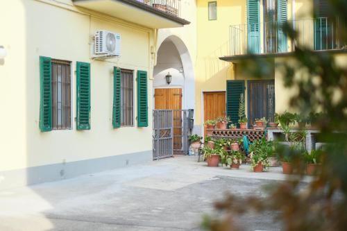 a courtyard of a building with green shutters and potted plants at Il Nido di Dedy in Florence