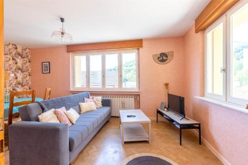 Una sala de estar con un sofá y un televisor. en Chez Mamie Wifi Un Séjour à Part, en Moyeuvre-Grande