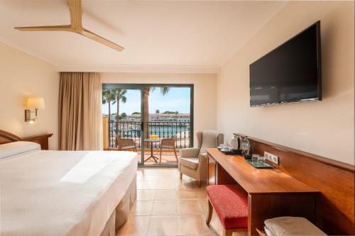 a hotel room with a bed and a flat screen tv at Valentin Star Menorca - Adults Only in Cala'n Bosch