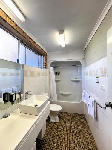 a white bathroom with a sink and a toilet at Colac Mid City Motel in Colac