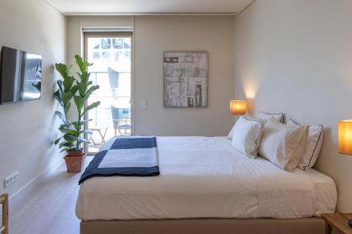 a bedroom with a large white bed and a window at Ocean Living by MP in Vila Nova de Gaia