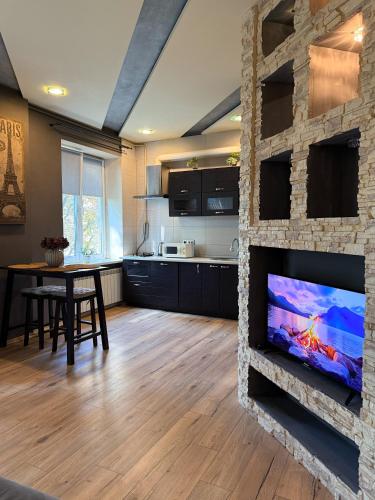 a living room with a stone wall with a flat screen tv at Kyiv Paris Apartment in Kyiv
