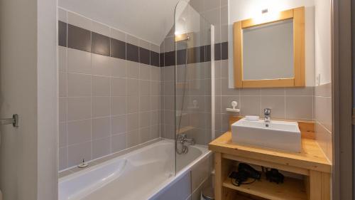 a bathroom with a sink and a tub and a mirror at J de Balnea B N 205 - 4P6 in Loudenvielle