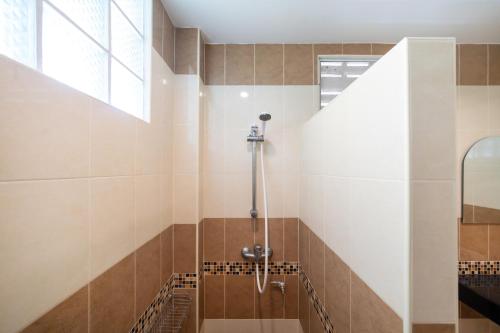a bathroom with a shower with brown and white tiles at Oceanview Bungalows by EAT in Karon Beach