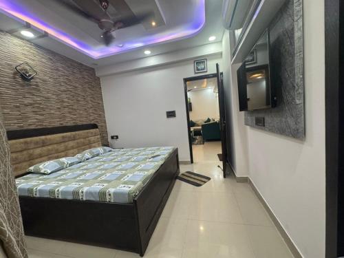 a bedroom with a bed and a tv on the wall at Pablo Place in Ghaziabad
