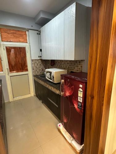 a small kitchen with a microwave on a counter at Pablo Place in Ghaziabad