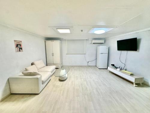 a living room with a couch and a flat screen tv at 경주펜션 Gyeongju Pension in Incheon
