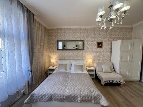 a bedroom with a bed and a chair and a chandelier at Romance in the Old Town in Prague