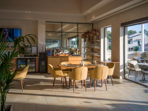 a dining room with a table and yellow chairs at Dreams Corfu Resort & Spa - All Inclusive in Gouvia