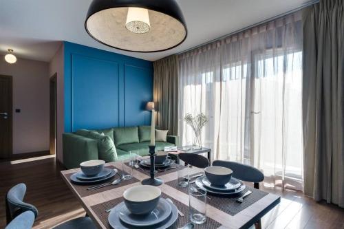 a living room with a table with chairs and a couch at Martinique Seaside FreeParking by Elite Apartments in Przymorze