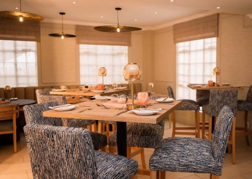 a dining room with a wooden table and chairs at 10 2nd Avenue Houghton Estate by Dream Resorts in Johannesburg