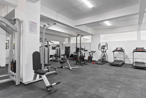 a gym with several treadmills and exercise bikes at Johari One Bedroom 11th Floor Apartment-Lavington in Nairobi