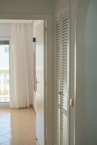 a room with white doors and a hallway with a floor at Apartamentos Dominique in La Manga del Mar Menor