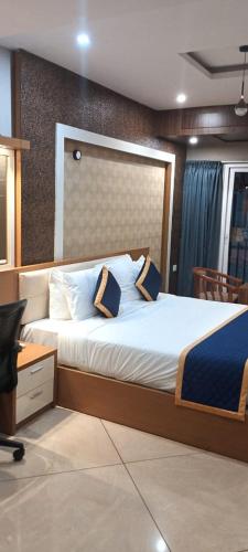 a bedroom with a large bed and a desk at Blue Diamond Residency in Perintalmanna