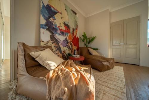 a living room with a couch and a painting on the wall at Family Friendly Funhouse close to All Theme Parks in Gold Coast