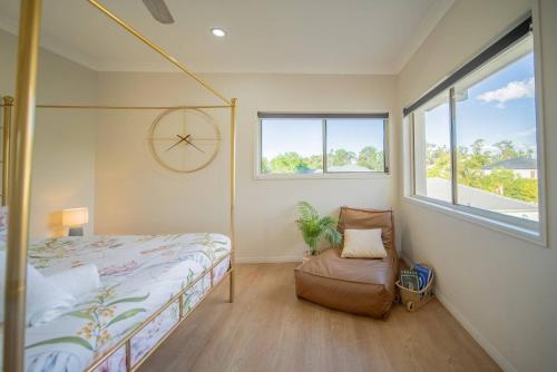 a bedroom with a bed and a chair and a clock at Family Friendly Funhouse close to All Theme Parks in Gold Coast