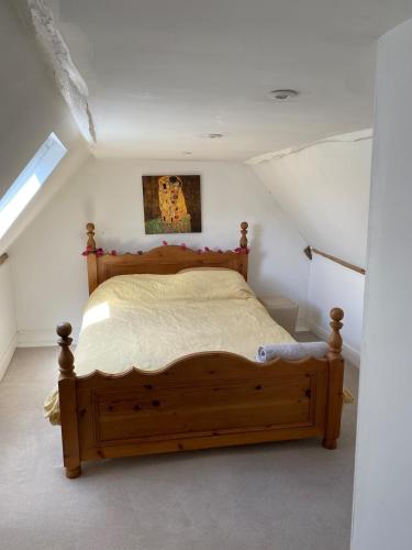 a bedroom with a wooden bed in a attic at The Deli, Wilton in Wilton