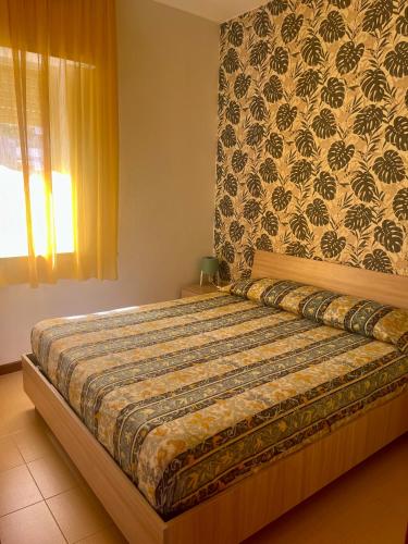 a bedroom with a large bed with a wall at Profumo di Mare 2 in Alcamo Marina