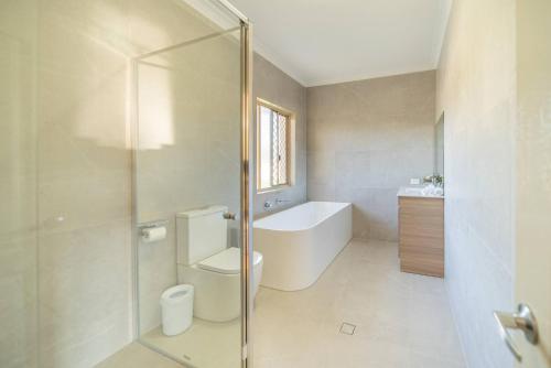 a bathroom with a shower and a toilet and a sink at Family Friendly Funhouse close to All Theme Parks in Gold Coast