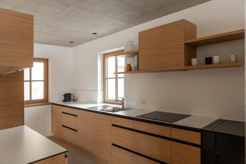 a kitchen with wooden cabinets and a sink at Haus Engadein in Auna di Sopra