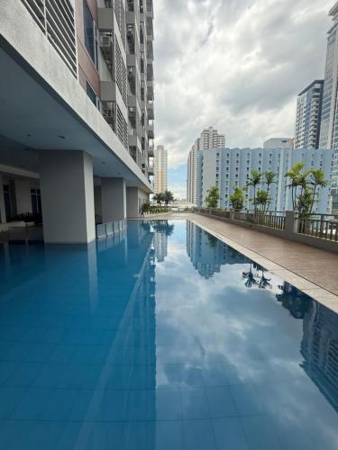 a pool in the middle of a city with tall buildings at Condo for Short Stay in Ermita near SLMEC & US Embassy in Manila
