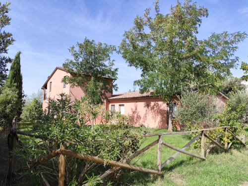 an old pink house with a fence and trees at Agriturismo Il Merollo in Todi