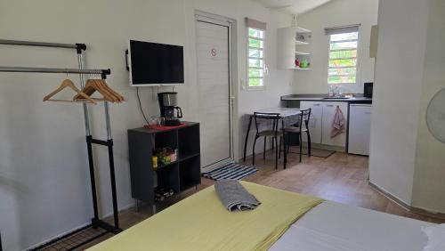 a living room with a bed and a kitchen at Tiny House & Tente Lodge, Le Paradis des Petits Voyageurs in Le Diamant