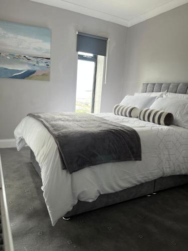 a white bedroom with a large bed with a window at Atlantic beach house in Dog Island