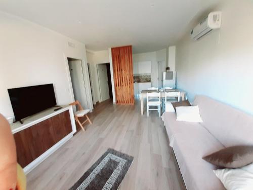a living room with a couch and a television at Guest Room Nesea in Pellaro