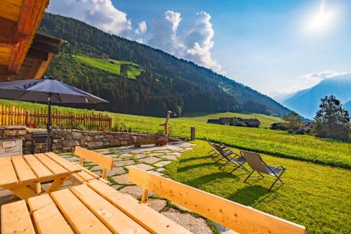 a patio with a table and chairs and an umbrella at Ferienhaus Oberschneider in Selva dei Molini