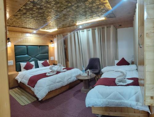 a bedroom with two beds with swans on them at The K2 Alpine in Pahalgām