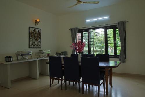 a dining room with a table and chairs at melberry villa in Sānand