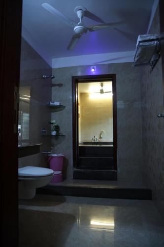 a bathroom with a white toilet and a sink at melberry villa in Sānand