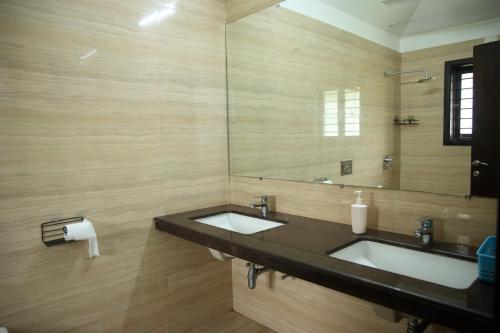 a bathroom with two sinks and a large mirror at melberry villa in Sānand